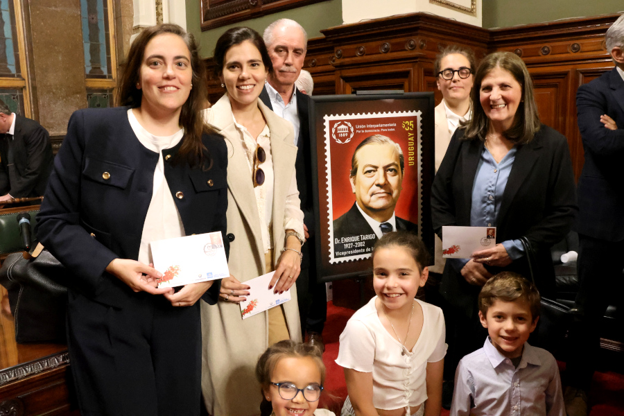 Familiares del Dr. Enrique Tarigo junto a la reproducción del sello conmemorativo