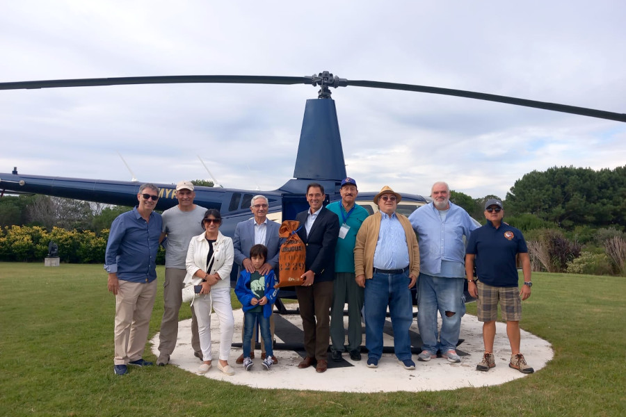 Autoridades participantes en el acto junto al helicóptero utilizado para el vuelo aeropostal