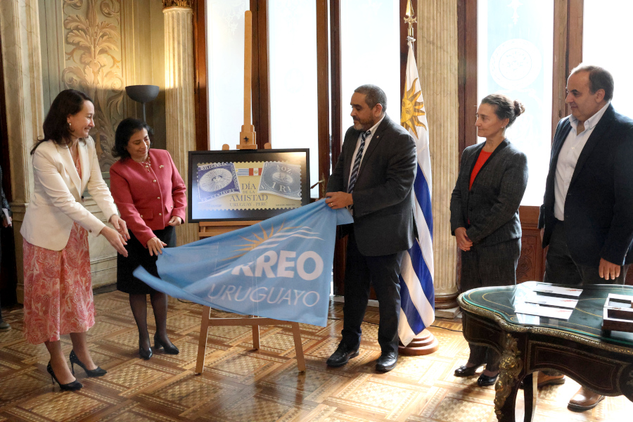 Autoridades presentes en la ceremonia descubren la reproducción del sello conmemorativo.