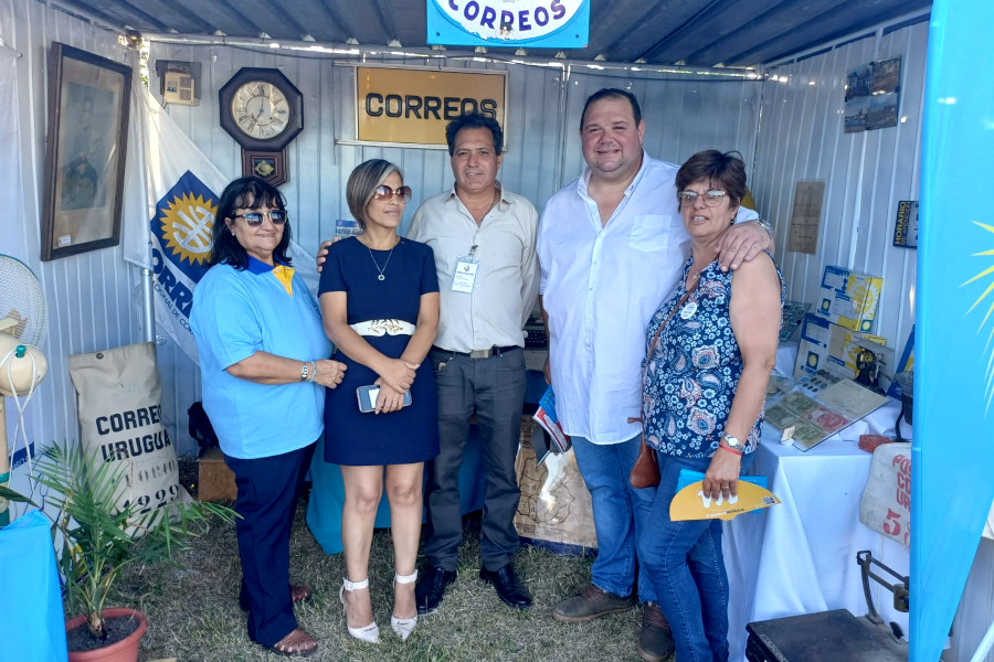 Funcionarios de Correo Uruguayo junto a visitantes en el stand